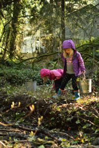 2 young children planting natives.