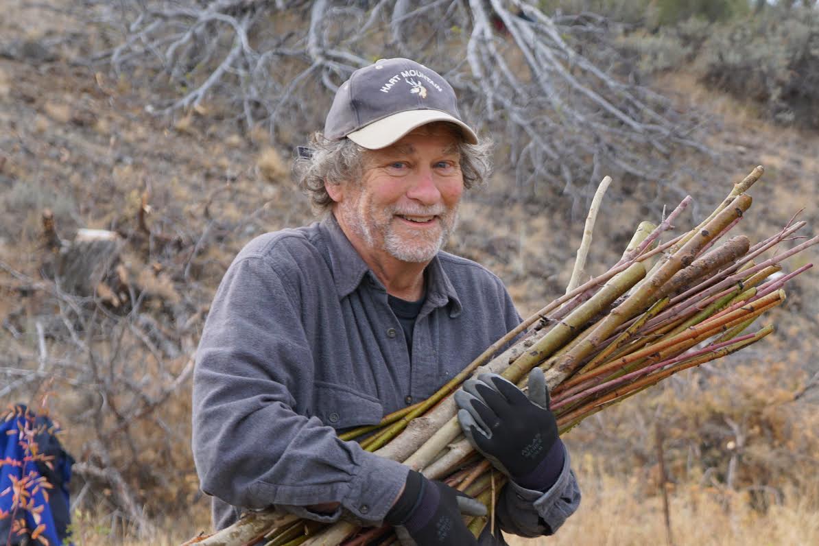 Board member Carl Axelsen, smiling and carrying a bundle of sticks.